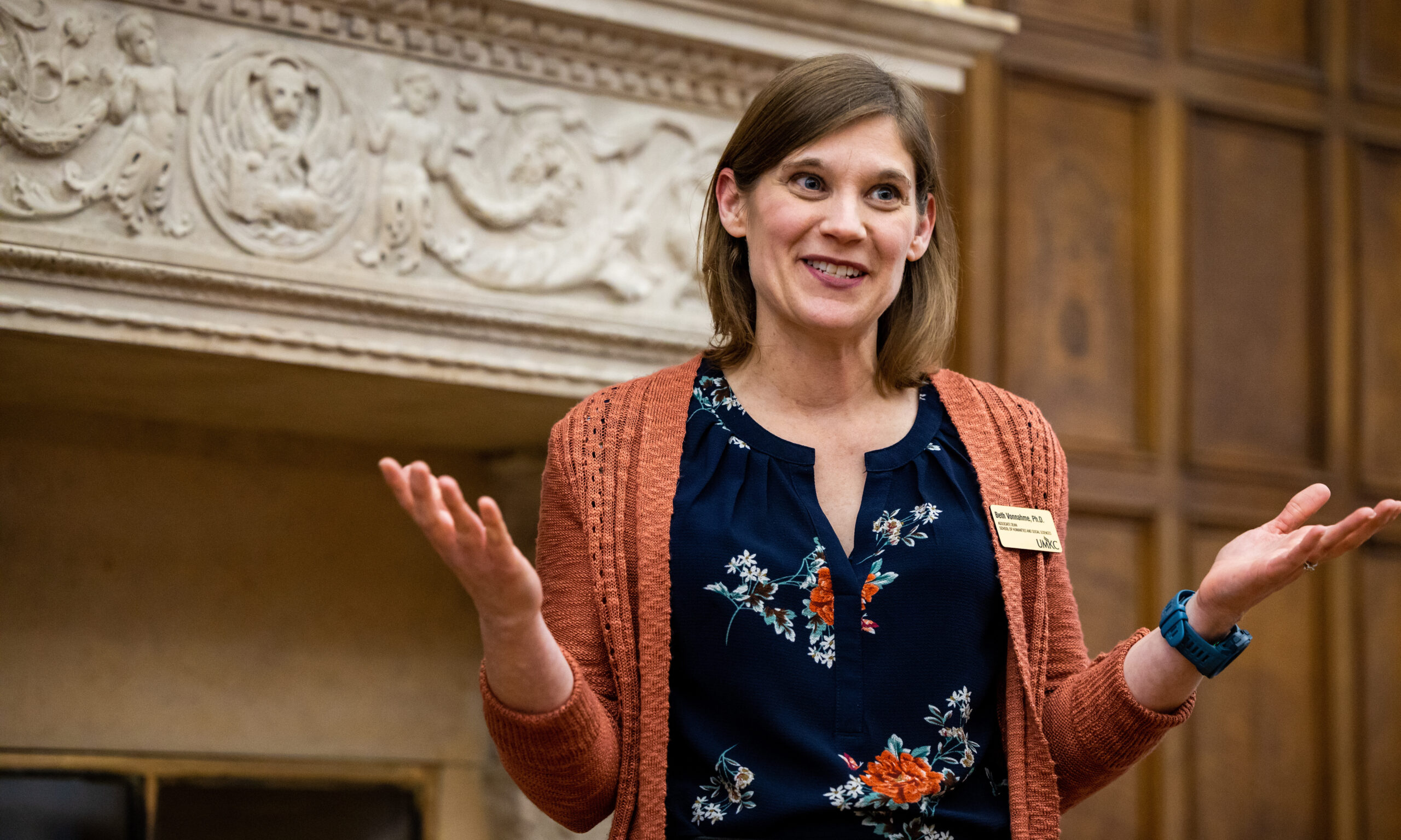Picture of Dr. Beth Vonnahme Speaking in front of Fireplace in Scofield Hall